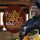 A smiling chef in a black uniform standing next to a bowl of collard greens and a copy of the Gifted Hands Soul Food Cookbook - Paperback, featuring family meals by Chef Carluse Baird.