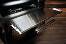 A stainless steel Pimp My Grill® Tactical Stainless Folding Front Shelf attached to a Recteq RT-800 / Deck Boss 800 pellet grill, featuring a paper roll holder underneath for extra prep workspace.