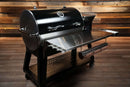 Pimp My Grill Tactical Stainless Folding Front Shelf for the Recteq RT-800 / Deck Boss 800, featuring a stainless folding shelf with a mounted paper towel holder for a convenient prep workspace.