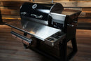 Black Recteq RT-800 / Deck Boss 800 pellet grill with a Pimp My Grill® Tactical Stainless Folding Front Shelf featuring a paper towel holder and a side accessory tray.