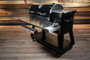 Pimp My Grill® Tactical Stainless Folding Front Shelf for Recteq RT-800 / Deck Boss 800, a stainless steel folding grill shelf featuring a paper towel holder and a side tray to create a convenient grill prep workspace.