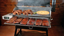 A Recteq RT-700 / RT-680 smoker grill with a Pimp My Grill® Gen2 Slide-Out Rack System - 2 Racks holding whole chickens, asparagus, a pie, and several racks of ribs.