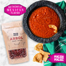 A stone bowl of red salsa with tortilla chips, a bag of Rico Rico Chile de Árbol Dried Chiles – Hot & Authentic Mexican Peppers, and a green cloth. Text reads Authentic Mexican Flavor and Rico Rico.