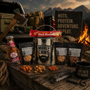 DDR BBQ Supply Manly Cans nut gift set with assorted snack bags, a nut roll, and a steel container on a wooden table.