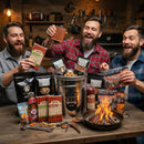 Three bearded men enjoy snacks and drinks around a table filled with jerky, nuts, and a Manly Cans 3.5 Gallon WeekCAN Warrior Gift Can, with a small campfire burning in a rustic, sports-themed room.