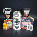 DDR BBQ Supply Manly Cans protein gift can featuring beef jerky, beef sticks, nuts, and a protein bar on dark surface