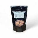 A black resealable pouch labeled Praline Pecans with visible nuts—perfect as a sweet alternative to meat snacks or for pairing with the Manly Cans 3.5 Gallon Snackage Gift Can.