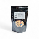 A black resealable pouch inside the Manly Cans 3.5 Gallon WeekCAN Warrior Gift Can contains Classic Trail Mix with nuts, chocolate, and dried fruit—one of Manly Cans’ savory snacks.