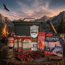A display of meat snacks, jerky, summer sausage, and a green Manly Cans 50 Cal CANivore Meat Gift Can—ideal for gifts—on wood outdoors with mountains, campfire, and axe. Brand: Manly Cans.