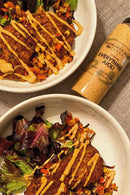 Two plates of crispy, gluten-free patties with chopped veggies and Terrapin Ridge Farms Everything Aioli Squeeze Garnishing Sauce, served with mixed greens. A 13 oz bottle of Terrapin Ridge Farms Everything Aioli is next to the plates.