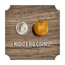 A large roasted corn kernel from the Rufus Teague Crunchin' Corn Variety Pack sits beside a U.S. dime on wood, with text "MIGHTY BIG CORNS!" emphasizing its impressive size and bold Rufus Teague snack flavor.
