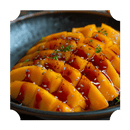Sliced mango on a black plate, topped with Rufus Teague Diablo Limonajo BBQ Sauce, garnished with sesame seeds and fresh herbs.
