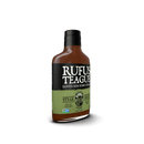 A bottle of Rufus Teague Steak Sauce features a black cap, black and green label with white “Loved Him Some Steak” text, a bearded man’s illustration, Non-GMO Project Verified logo, and highlights this bold gluten-free sauce.