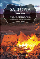 A campfire glows surrounded by rocks, with open plains and a vivid sunset behind. Text at top reads SALTOPIA Infused Sea Salts—Applewood Smoked Salt: GREAT OUTDOORS.