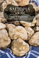 Close-up of Italian white truffles on a blue plaid cloth beside SALTOPIA Infused Sea Salts' truffle salt, DIRTY WEDDING, with its product label in white text over a black background.