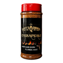 A jar of Scott’s Smoked Q Chesapeake Dry Rub Sweet Smoky Coastal BBQ Seasoning by Scott’s Smoked Q is surrounded by a bowl of the dry rub, grilled meat, fresh herbs, and flames, with smoke rising against a dark wooden background.