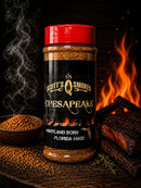 A jar of Scott’s Smoked Q Chesapeake Dry Rub Sweet Smoky Coastal BBQ Seasoning by Scott’s Smoked Q is surrounded by a bowl of the dry rub, grilled meat, fresh herbs, and flames, with smoke rising against a dark wooden background.