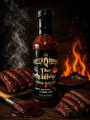A bottle of Scott’s Smoked Q The Spicy Original Sweet Garlic BBQ Sauce with Heat from Scott’s Smoked Q sits surrounded by glazed ribs, a sauce brush, a bowl of zesty sauce, and flames in the background, evoking a smoky barbecue atmosphere—the perfect choice for anyone craving rich smoked barbecue flavor with a kick of heat and sweet garlic.
