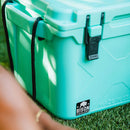 Seafoam cooler by Bison, shown in a close-up shot on green grass with black rope.
