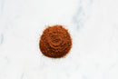 A small mound of richly flavored, finely ground World Spice Shawarma Spice sits on a white marble surface.