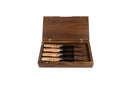 An open wooden box showcases four handcrafted steak knives with wooden handles, neatly arranged inside against a white background—evoking the elegant presentation of the Steelport Knife Co. Steak Knife Set by Steelport Knife Co.