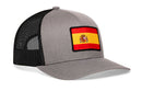 Haka Hat Spain Flag International Trucker Hat, a grey trucker hat with a black mesh back and a Spanish flag patch on the front.