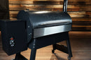 Black pellet grill with a Pimp My Grill® Bodyguard Stainless Steel Grease & Paint Protector attached to the front of the lid.