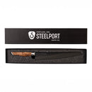 The Steelport Knife Co. 10" Bread Knife, crafted in the USA, features a wooden handle and is presented in a sleek black box adorned with the Steelport Knife Co. logo and “Portland, Ore.” on the lid. This American-made kitchen knife blends artisanal craftsmanship with precision for all your bread-slicing needs.