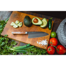 A Steelport Knife Co. 6" Chef Knife rests elegantly on a wooden cutting board, surrounded by fresh avocados, lime wedges, a jalapeño pepper, salt, pepper, tomatoes, cilantro, and green onions—creating the perfect setup for preparing fresh ingredients with premium craftsmanship.