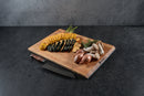 A Steelport Knife Co. Everyday Knife & Board Set, featuring a premium chef knife and wooden cutting board, displays sliced zucchini, shallots, oyster mushrooms, and fresh herbs on a dark countertop.