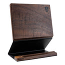 The Steelport Knife Co. Knife Block by Steelport Knife Co. features a dark walnut finish and an angled design, with a magnetic surface that securely holds knives upright and displays a small logo in the top corner. This magnetic knife block provides practical storage for your kitchen knives, while its flat, sturdy base ensures reliable stability on your countertop.
