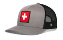 The Haka Hat Swiss Flag Trucker Hat by Haka Hat features a solid gray front and black mesh back and sides for ventilation. A bold red patch with a white cross on the front celebrates classic Swiss style, bringing distinctive flair to any casual outfit. This Switzerland Snapback offers all-day comfort with its adjustable fit, seamlessly combining tradition and modern design.