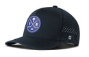 The Haka Hat Tampa Bay Hockey Performance 5-Panel Hat | TB X Flexfit Snapback is a dark blue cap featuring a round logo with crossed hockey sticks, a palm tree, and the letters T and B. It includes small ventilation holes on the side and is designed with a comfortable Flexfit sweatband for a perfect fit.