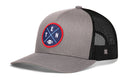 The Haka Hat Tennessee Trucker Hat | Black TEN X Football Snapback features a gray front, black mesh back, and a round blue patch with white “T” and “EN” in red circles, crossed lines, and a small football icon at the center—making this classic Haka Hat perfect for any Nashville football fan.