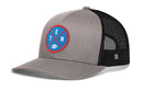The Haka Hat Tennessee Football Trucker Hat | Columbia Blue TEN X Snapback features a gray and black mesh snapback design with a blue and red circular patch on the front, showcasing crossed lines, the letters T, E, and N, and a small white football icon—making it an ideal addition to any Tennessee Football Trucker Hat collection.