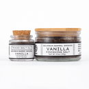 Two glass jars with cork lids hold Texas Salt Co. Bourbon Barrel Smoked Vanilla Finishing Salt, made with Madagascar vanilla. The jars have white labels with black text; the larger jar is positioned to the right.