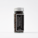 A small glass jar with a silver lid holds Texas Salt Co. Mesquite Smoked Peppercorn, a bold smoked seasoning. Its black label shows the product name and net weight of 2 oz (56g) on a white background.