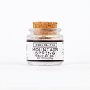 A small clear glass jar with a cork lid, labeled Texas Salt Co. Mountain Spring Peruvian Salt, Net Wt 1oz (28g), on a white background. This mineral-rich salt is sourced from pristine Peruvian mountains.