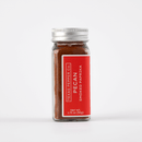 A glass spice jar with a silver lid holds 1.75 oz (50g) of pecan smoked paprika. The label reads “Texas Salt Co. Pecan Smoked Paprika” in white on red—ideal for adding smoky flavor to BBQ seasoning blends.