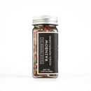 A clear glass jar of Texas Salt Co. Rainbow Peppercorn, featuring a black label, silver screw-on lid, and filled with a blend of premium rainbow peppercorns. The jar contains 2.25 oz (64g) of mixed peppercorns.