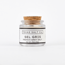 A 0.75 oz (21g) glass jar with a cork lid labeled Texas Salt Co. Sel Gris French Salt, from Texas Salt Co, filled with mineral-rich sea salt and shown on a plain white background.