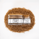 Two jars of Texas Salt Co. Tequila Barrel Smoked Lime Finishing Salt rest atop a mound of the citrus, smoke-infused salt, set against a white background. The clear labels show the Texas Salt Co brand and product details.
