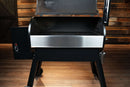 A pellet grill with its lid open, featuring a Pimp My Grill® Bodyguard Stainless Steel Grease & Paint Protector installed along the front edge of the main cooking chamber.