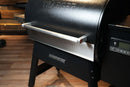 Pimp My Grill® Bodyguard Stainless Steel Grease & Paint Protector for the Ridgeline XL attached to the lid handle of a black pellet grill.