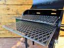 Two Pimp My Grill® Pro Series Slide-Out Rack System - 2 Racks metal slide-out grill racks with a diamond-pattern grate installed inside a black pellet grill to create a dual-zone grilling setup.