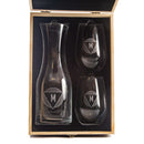 A Wine Decanter - The Modern set featuring a personalized glass decanter and two stemless wine glasses with custom engraved letter M emblems, displayed in an open wooden gift box.