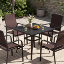 The DirectDeals 5 Pieces Patio Dining Set for 4 Outdoor Square Table and Stackable Chairs sits on a patio with iced drinks, flowers, fruit, and lush greenery against a stone wall backdrop.