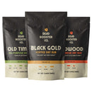Three Dead Rooster Co. dry rub packets—Old Time (green), Black Gold (black), and Redwood (red)—stand upright, each displaying icons for the meats they complement, like beef, chicken, pork, and fish. The Dead Rooster Co Variety Pack - 3 Signature BBQ Rubs Bundle & Save is the ultimate seasoning bundle from Dead Rooster Co., perfect for enhancing all your favorite dishes.