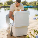 White 25 QT cooler by Bison with an open lid on a wooden dock by a lake.