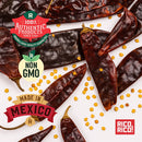 Rico Rico Guajillo Dried Chiles – Authentic Medium Heat Mexican Peppers by Rico Rico are scattered on a white background with text labels: 100% Authentic Products, Non GMO, Made in Mexico, and Rico Rico! along with some loose chili seeds—perfect for authentic Mexican cooking with the finest Guajillo peppers.